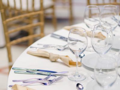 Beautifully arranged wedding table setting with fine cutlery and glassware, ideal for receptions.