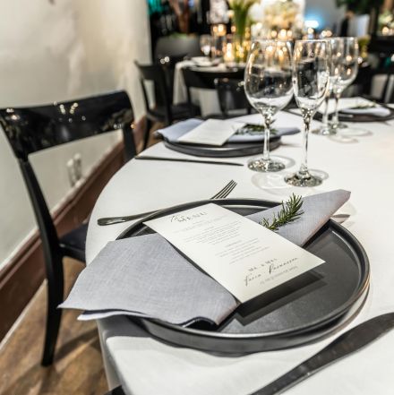 Elegant table setting with a menu and wine glasses, perfect for dinner events.